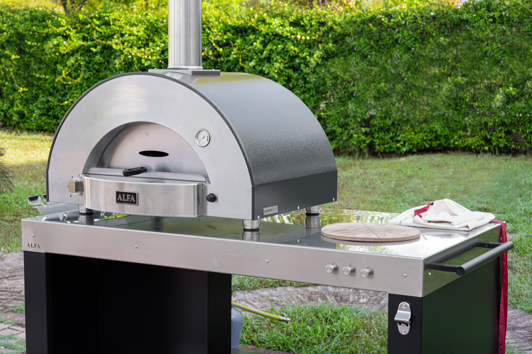 Cooking station with shelf storage and peel board in garden