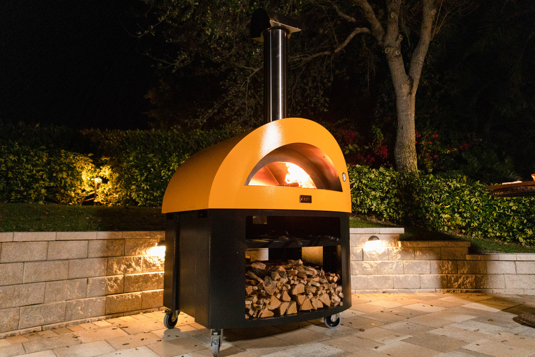 Moderno 5 Pizze on support base at night in landscaped garden
